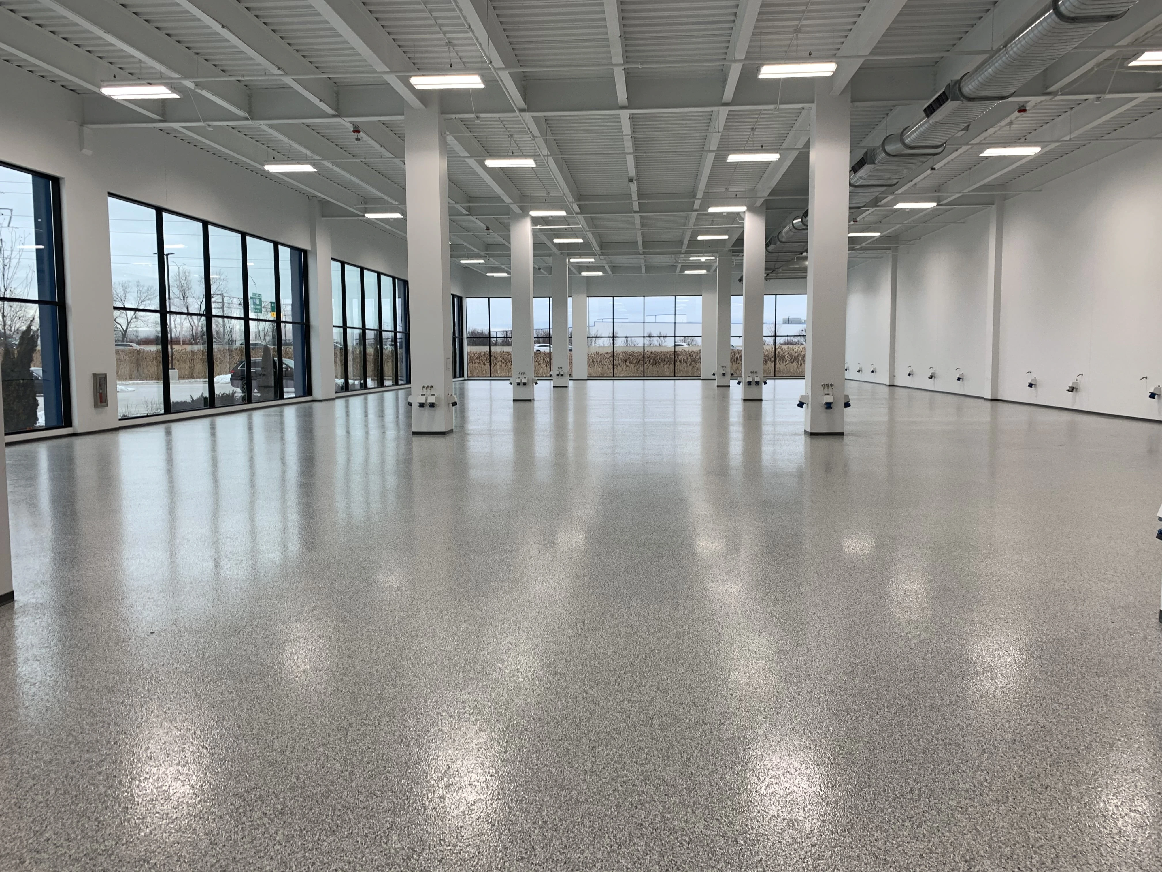 Full flake epoxy floor in a modern showroom A full flake epoxy floor installed in a showroom, offering a durable, decorative finish with vibrant texture and a polished look.